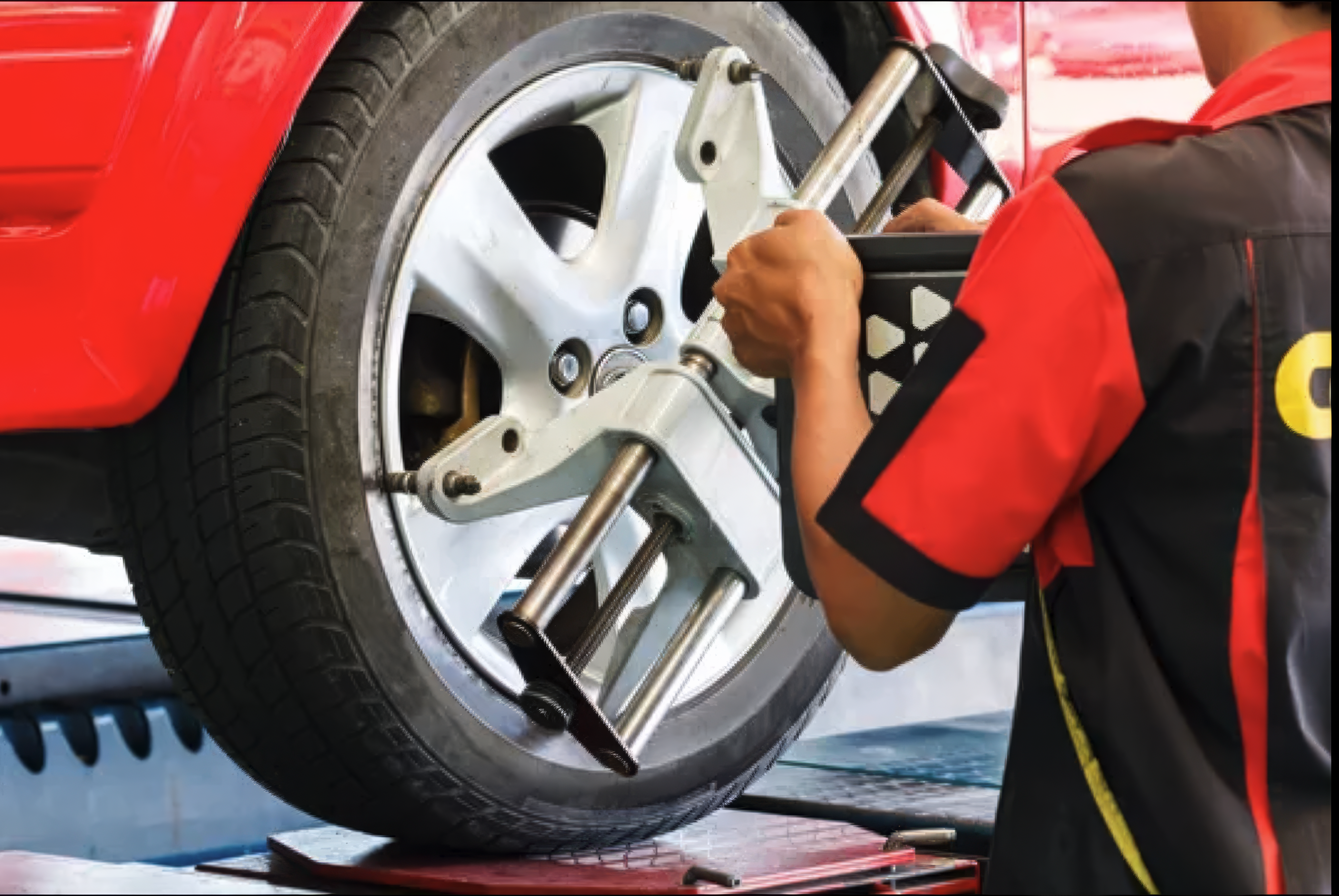 Technician attaching wheel alignment sensor Koreatown Los Angeles Western Auto Glass and Tire